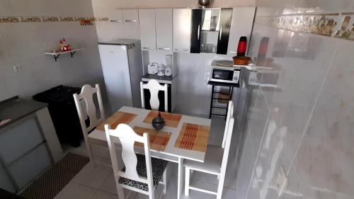 a small kitchen with a table and a refrigerator at Ap06-A 50 Metros da Praia Flats Mobiliados para 4 Pessoas in Paulista