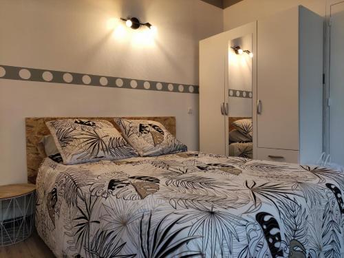 a bedroom with a bed with a black and white comforter at Studio éco proche du phare in Calais