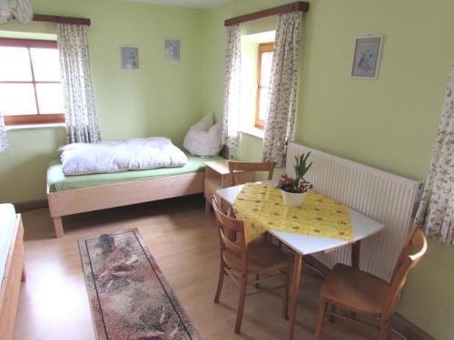 a room with a table and a bed and a dining room at Ferienwohnung Öderhof in Saaldorf