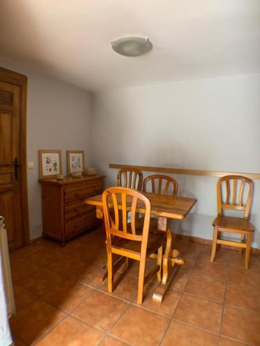 a dining room with a wooden table and two chairs at Casa La Fragua in La Hiruela