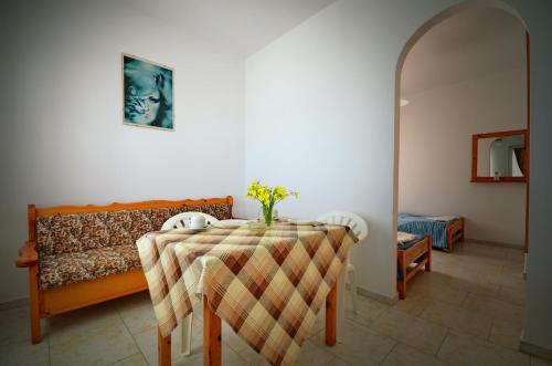 ein Esszimmer mit einem Tisch und einem Sofa in der Unterkunft Studio Anthoula in Kefalos