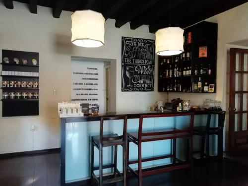 a bar in a restaurant with two stools at Pórtico Hotel & Galería in Morelia