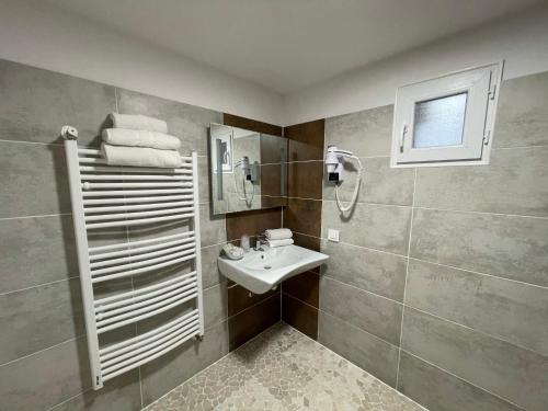 y baño pequeño con lavabo y ducha. en Hôtel Le Moulin D'Olt, en La Canourgue