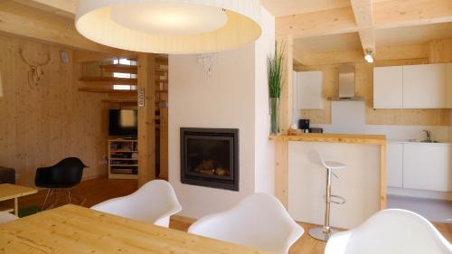 ein Wohnzimmer mit einem Tisch und einem Kamin in der Unterkunft Chalet Triebenstein in Hohentauern