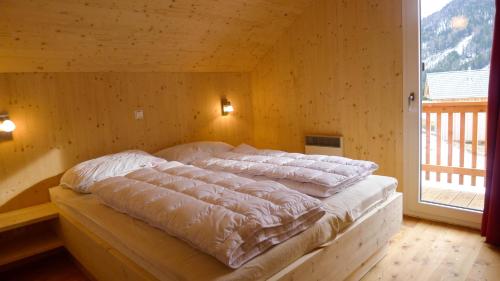 Bett in einem Zimmer mit einer Holzwand in der Unterkunft Chalet Triebenstein in Hohentauern