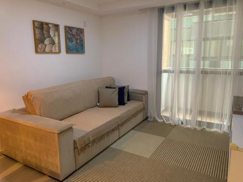 uma sala de estar com um sofá e uma janela em Apt 2qts 01 suíte BeiraMar PontaVerde Edf Neo 2 1 em Maceió