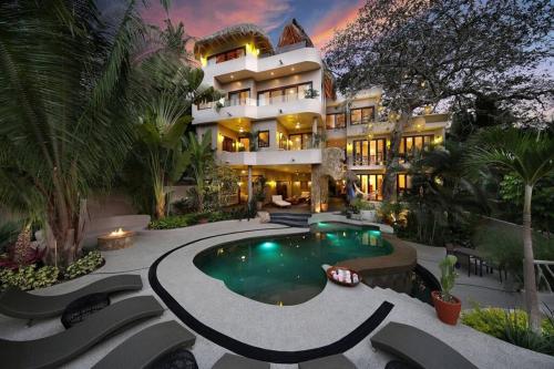 a large building with a swimming pool in front of it at Casa Sayulita, MISTIKA in Sayulita