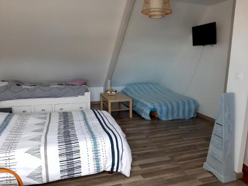 1 dormitorio con 1 cama y TV. en Comme chez vous, en Le Torp-Mesnil