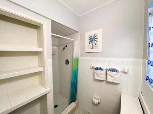 uma casa de banho com um chuveiro e um lavatório. em Surf Studio Beach Resort em Cocoa Beach