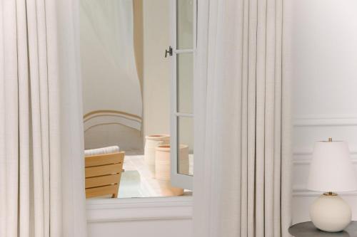 a room with a mirror and a table with a lamp at Cara Hotel in Los Angeles