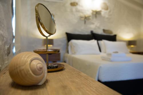 a mirror on a table next to a bed at Afentiko Pigadi in Methoni