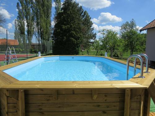 une piscine en bois avec une terrasse en bois et un bassin profond en bois. dans l'établissement Character house with pool jacuzzi, à Gondrecourt-le-Château