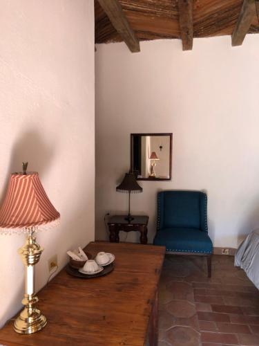 a living room with a table and a blue chair at Hotel Amor y Paz in Real de Catorce
