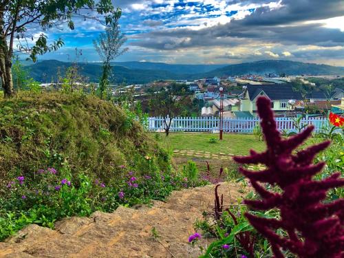 a view of a city from a garden with flowers at Cánh Đồng Mây Homestay Đà Lạt in Ấp Ða Lôc