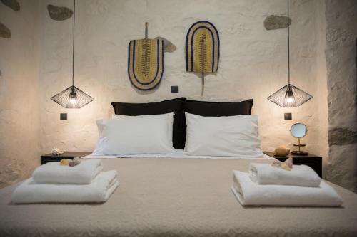 a bedroom with a large white bed with two pillows at Afentiko Pigadi in Methoni