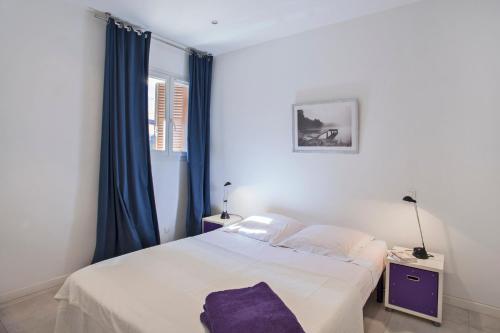 - une chambre avec un lit blanc et des rideaux bleus dans l'établissement Casa Estel - Blue apartment in downtown of Erbalunga, à Brando