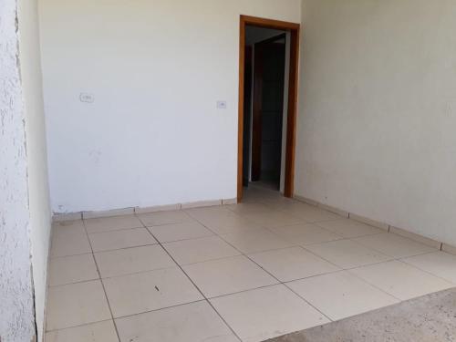 ein leeres Zimmer mit weißem Boden und einer Tür in der Unterkunft Cantinho do Nono in Campos do Jordão