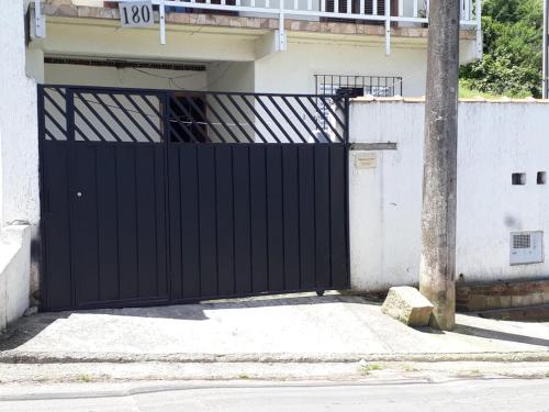 ein schwarzes Tor vor einem Haus in der Unterkunft Cantinho do Nono in Campos do Jordão