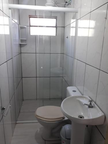 ein weißes Bad mit einem WC und einem Waschbecken in der Unterkunft Cantinho do Nono in Campos do Jordão