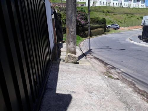 einen Zaun an der Seite einer Straße mit einer Stange in der Unterkunft Cantinho do Nono in Campos do Jordão