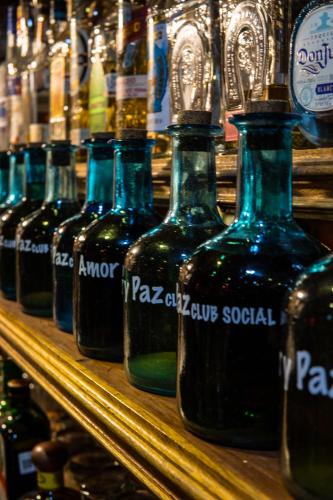 a row of bottles of wine on a shelf at Hotel Amor y Paz in Real de Catorce