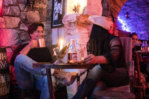 a man and a woman sitting at a table in a bar at Hotel Amor y Paz in Real de Catorce