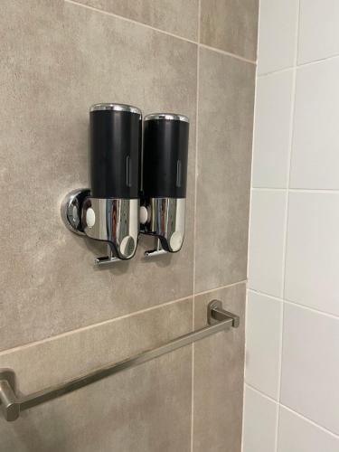 Baño con 2 tazas de café en la pared en Leguizamon Studios & Suites Premium en Salta