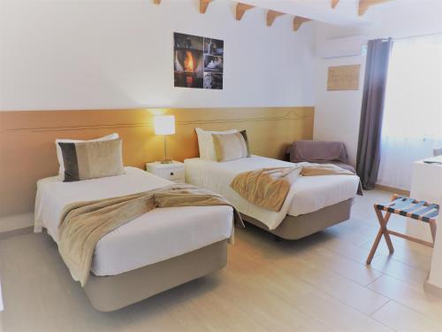 a bedroom with two beds and a table in it at Vila Barca in Madalena