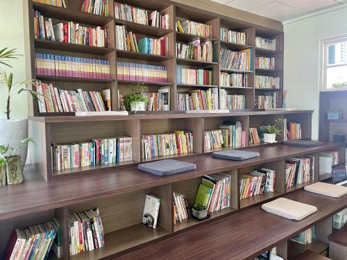 a library with wooden shelves filled with books at Little Garden Dream Life Home in Nantou City