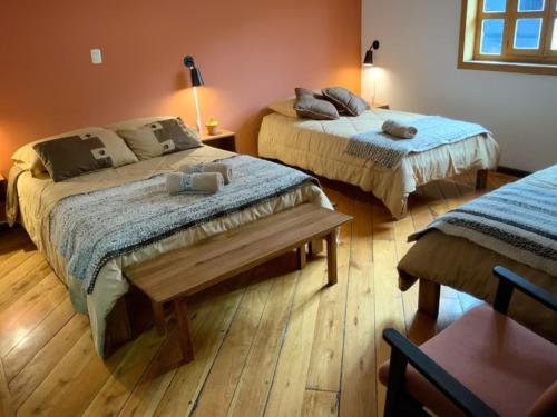 two beds in a room with wooden floors at Ñañas Hostel in Cuenca
