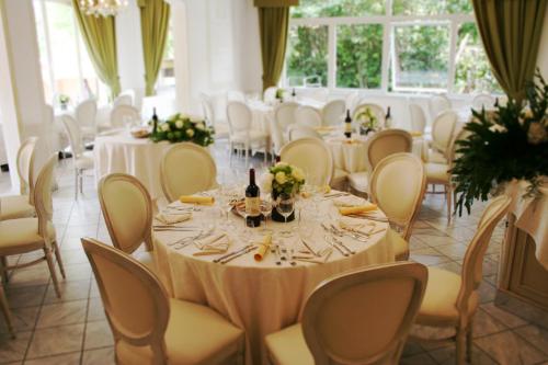 a banquet hall with tables and chairs with wine bottles at Hotel La Pigna in Marina di Pietrasanta