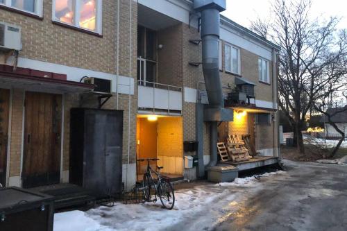 a bike parked outside of a building in the snow at Yksiö 1 km jokirannasta föriltä/ 2 km torilta in Turku