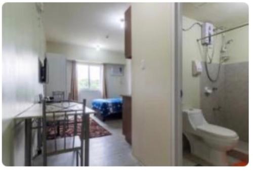 a bathroom with a sink and a toilet in a room at Staycation condo with pool near SM Tungko, Bulacan in Mangangpico