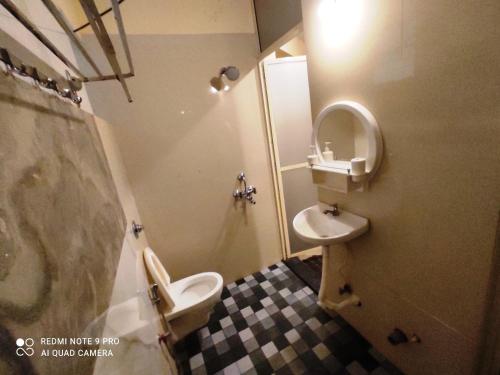 a bathroom with a toilet and a sink at Godwill Kimo Guest house Seraulim in Madgaon
