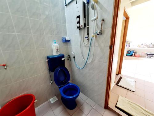 La salle de bains est pourvue d'une douche et de toilettes bleues. dans l'établissement Pangkor Homestay, à Île de Pangkor