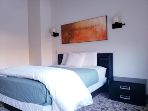 a bedroom with a bed and a painting on the wall at Lowell Inn in Stillwater
