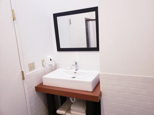 a bathroom with a white sink and a mirror at Lowell Inn in Stillwater