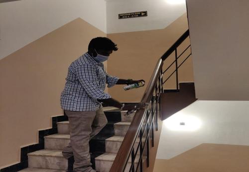 a man in a mask is going down the stairs at Arudhra Residency in Chidambaram
