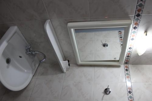 La salle de bains est pourvue d'un lavabo et d'un miroir. dans l'établissement Hotel Avra, à Vólos