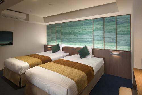 two beds in a room with a large window at Tateshina Grand Hotel Takinoyu in Chino