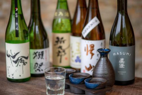 a group of wine bottles on a table with a glass at Tateshina Grand Hotel Takinoyu in Chino