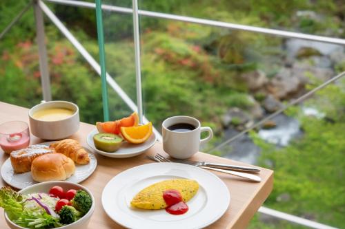 a table with plates of food and two cups of coffee at Tateshina Grand Hotel Takinoyu in Chino