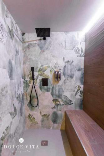 a bathroom with a stone wall with a shower at Apartamento Roma, living suite en Vila real in Villareal