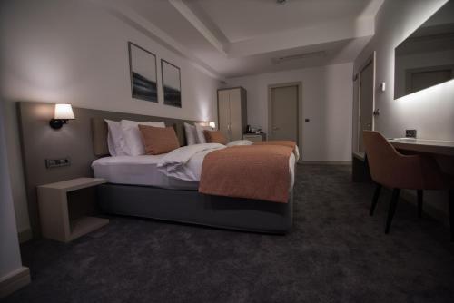 a bedroom with a large bed and a desk at Dovv Hotel Busıness in Gaziemir