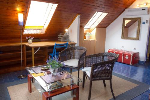 ein Wohnzimmer mit Stühlen, einem Tisch und Oberlichtern in der Unterkunft Apartment Nikola in Makarska