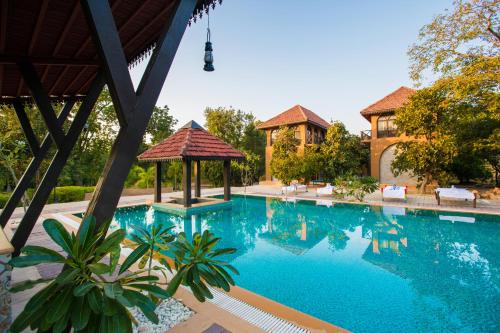 a large swimming pool with a gazebo at Vannraj Resort And Spa in Khawāsa