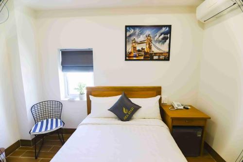 a bedroom with a bed and a table and a chair at Sea Star Hotel Quy Nhon in Quy Nhon