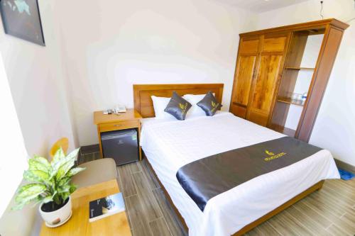 a bedroom with a bed and a table with a plant at Sea Star Hotel Quy Nhon in Quy Nhon