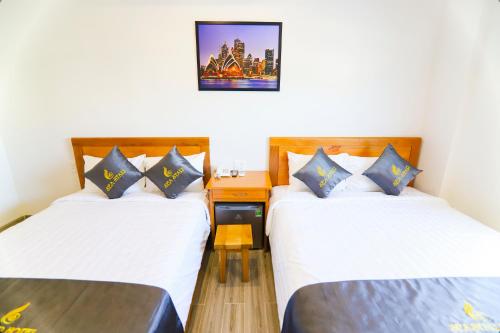 a room with two beds and a picture on the wall at Sea Star Hotel Quy Nhon in Quy Nhon