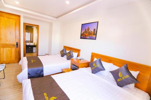 a hotel room with two beds and a tv at Sea Star Hotel Quy Nhon in Quy Nhon
